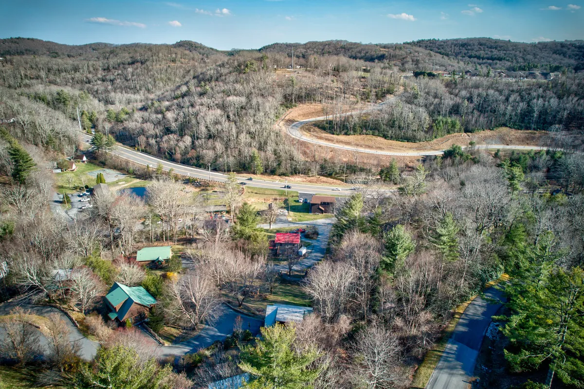 A scenic view of the winding road through forest-covered hills and scattered houses, evoking the natural beauty and opportunities for exploration in the Timber Ridge community and beyond.