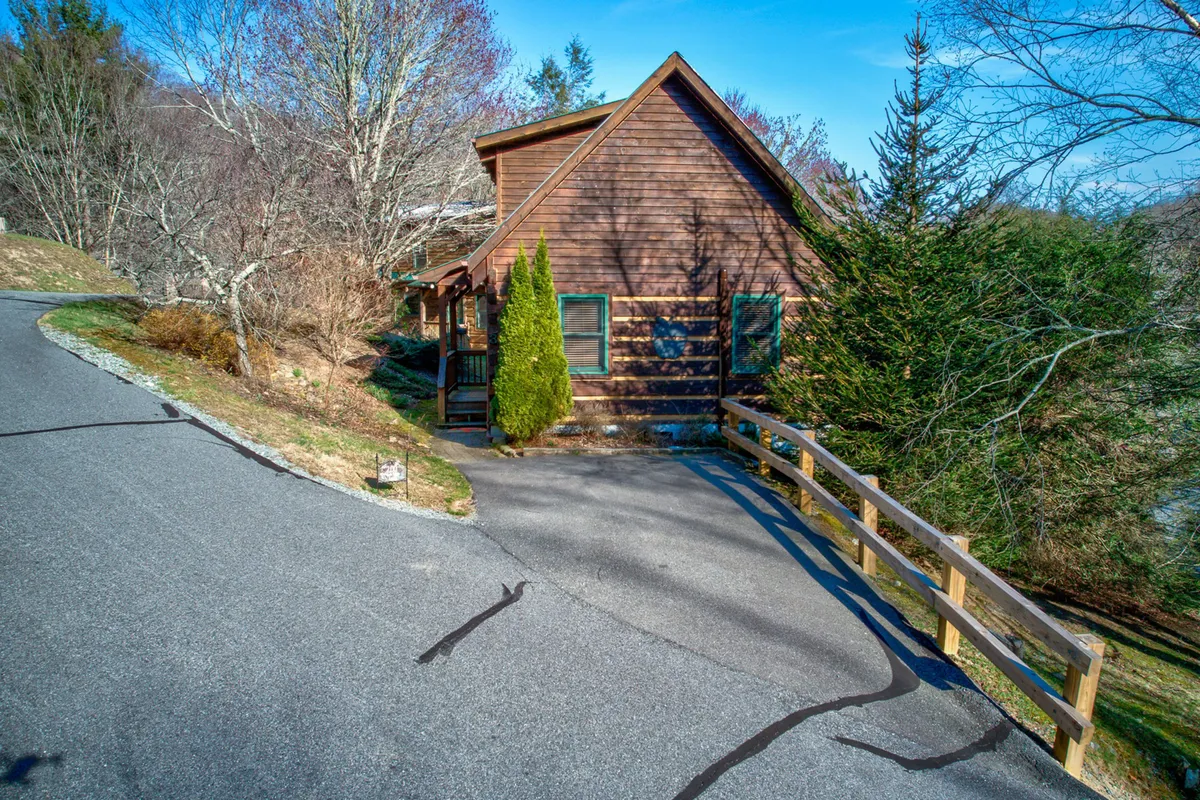 This image captures the Apple Cabin’s wooden exterior, surrounded by lush green shrubbery and set alongside a curved driveway and rustic rail fence. The peaceful setting invites relaxation and outdoor exploration, hinting at the welcoming environment for both guests and their pets.